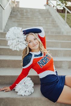 a cheerleader sitting on the steps with her pom poms