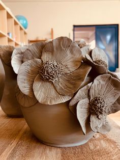 a vase with flowers sitting on top of a wooden table