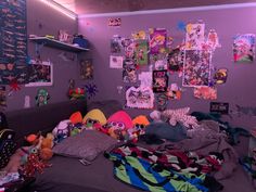 a messy room with many stuffed animals and pictures on the wall, including one person's head