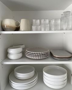 white dishes and plates on shelves in a kitchen