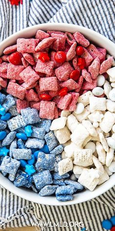 a bowl filled with marshmallows, red and blue candies and candy