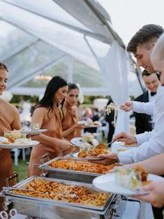 a group of people are serving themselves food