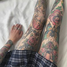 a woman laying on top of a bed covered in tattoos