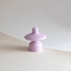 a purple candle sitting on top of a white table