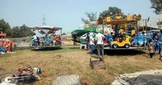 several people are standing around in front of an amusement park ride