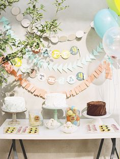 a table topped with lots of desserts and balloons