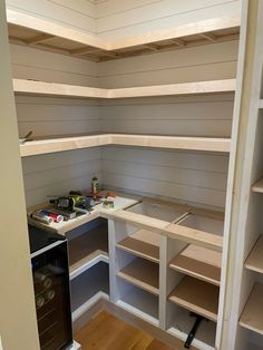 an empty pantry with shelves and tools on the counter