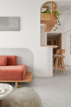 a living room with an orange couch next to a white table