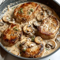 some meat and mushrooms are in a pan on a table with gravy over it