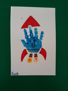 a hand print on a white paper with blue and orange colors, depicting a rocket ship