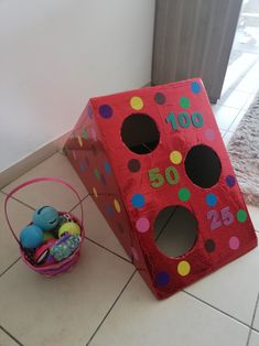 a red cardboard box with polka dots on it next to an easter basket