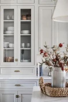 a white kitchen with lots of glass cabinets