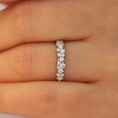 a woman's hand with a diamond ring on her left hand, showing the side view