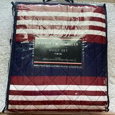 an american flag quilted luggage bag on the floor in front of a white carpet