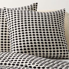 two black and white pillows sitting on top of a couch next to a pillow case