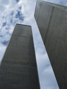 two tall skyscrapers against a cloudy blue sky