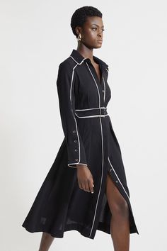 Feel Confident In Our Midi Dress, With A Shirt Style Design Featuring A Formal Collar, As Well As A Belted Waist For A Cinched Silhouette, And A Long, Flared Skirt. Style It With Block Heels Or Ankle Boots For A Look Perfect For Office Days, Then Wear It With Heeled Boots Or Strappy Heels For An Evening Look. Fluid Tailored Tipped Belt Detailed Midi Shirt Dress Flattering Fit And Flare Silhouette Unique Contrasting Trim Details V Neckline Unique Collar Detailing Belted Waist Feature Relaxed, Fla Luxury Belted Shirt Dress For Office, Luxury Belted Collared Shirt Dress, Belted A-line Shirt Dress For Work, Chic Long-sleeve Shirt Dress With Belted Cuffs, Luxury Belted A-line Shirt Dress, Long Flared Skirt, Bride Jumpsuit, Workwear Capsule Wardrobe, Petite Midi Dress