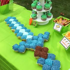 a table topped with cupcakes covered in blue frosting and green icing