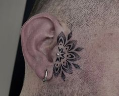 a man with a tattoo on his side behind the ear