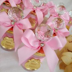 pink and gold candy jars with bows on them are sitting next to some teddy bears