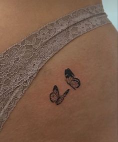 a woman's stomach with two butterflies tattoo on her side ribcadings