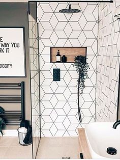 a bathroom with a white tiled shower and black accents on the walls, along with a poster above the tub