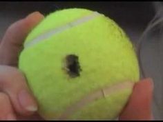 a person holding a tennis ball with a hole in it