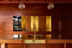 a kitchen with wooden cabinets and two hanging lights above the countertop, along with an island