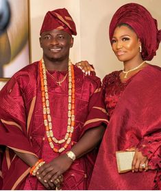 a man and woman dressed in red standing next to each other with beads on their necklaces