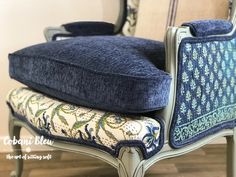 an upholstered chair with a blue cushion on it