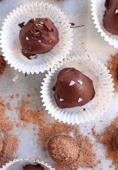 chocolate truffles are arranged in white paper cups