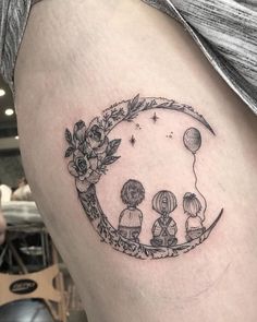 a woman's thigh with an image of three people sitting on the moon