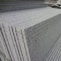 several stacks of granite sitting next to each other on top of a pile of metal sheets