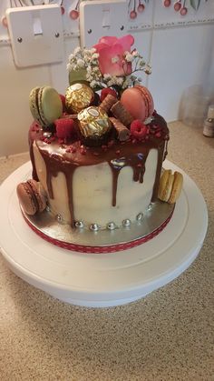 a cake with chocolate icing and candies on top sitting on a countertop