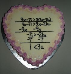 a cake shaped like a heart with writing on the side and numbers written in pink frosting