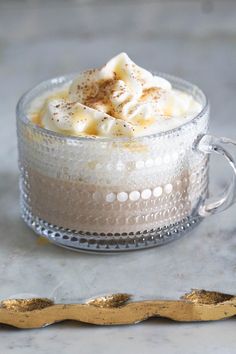 a glass cup filled with whipped cream and topped with cinnamon sprinkled on top