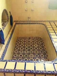 a bathroom with blue and white tiles on the floor, walls and bathtubs