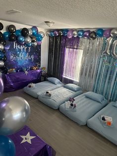 a room decorated with balloons, sheets and bedding for a children's birthday party