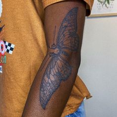 a man with a butterfly tattoo on his arm