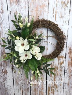 a wreath with white flowers and green leaves