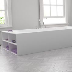 a white bath tub sitting under a window next to a shelf filled with purple towels