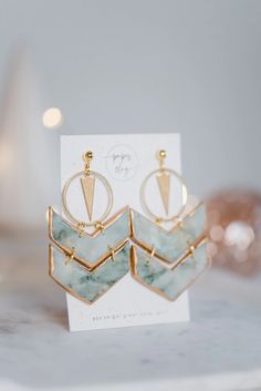 the earrings are on display in front of a card