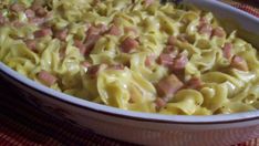 a casserole dish with ham and cheese in it on a red table cloth