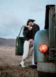 a man and woman sitting on the back of a truck