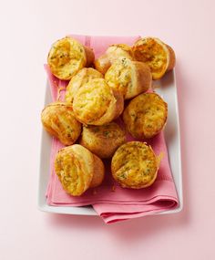 a white plate topped with muffins on top of a pink napkin