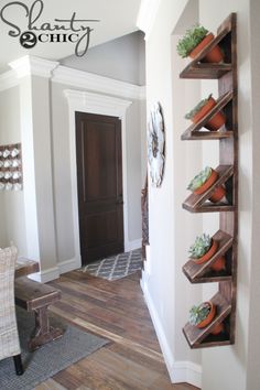 an entry way with wooden shelves and plants on the wall