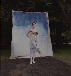 a woman is standing in front of a backdrop