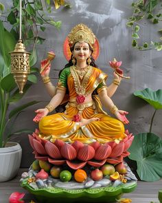 there is a statue of the hindu god sitting on top of a lotus flower arrangement