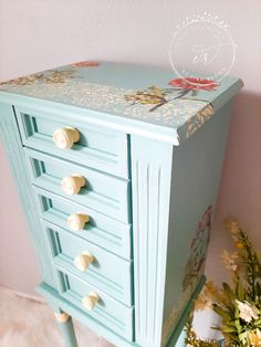 a blue painted dresser with drawers and knobs