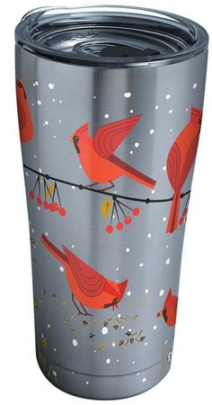 a stainless steel tumbler with red birds and berries on the side, sitting on a branch